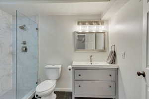 Bathroom with vanity, toilet, and tiled shower