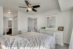 Bedroom featuring carpet, connected bathroom, ceiling fan, and a closet