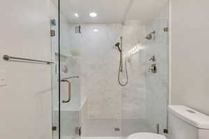 Bathroom with a shower with shower door and toilet