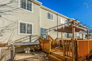 Back of property with a deck and a pergola