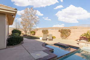 View of patio / terrace with a mountain view and a pool with hot tub