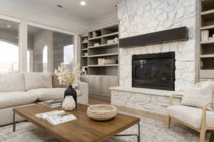 Living room featuring hardwood / wood-style flooring, ornamental molding, and a fireplace