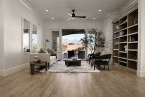 Sitting room featuring crown molding, hardwood / wood-style flooring, a mountain view, built in features, and ceiling fan