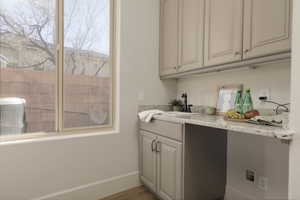 Laundry room featuring sink and hardwood / wood-style floors