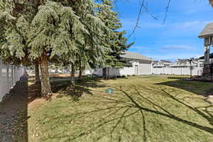 View of yard featuring fence and a garage