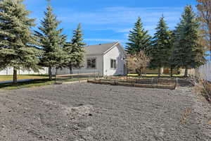 View of side of home featuring a vegetable garden and fence