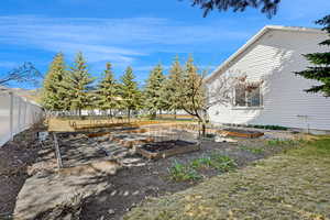View of yard with fence and a garden