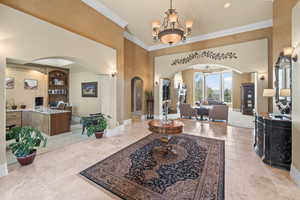 Entryway featuring crown molding and a chandelier