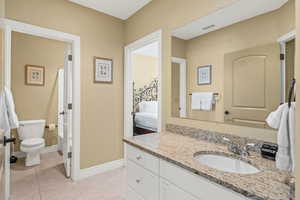 Bathroom with toilet, vanity, and tile patterned flooring