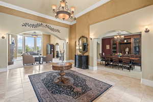 Entrance foyer with a notable chandelier and crown molding