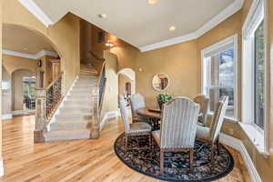 Dining area featuring light wood-type flooring and crown molding