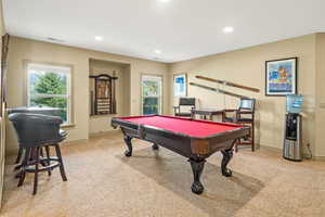 Game room with light colored carpet, pool table, and a healthy amount of sunlight