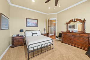 Bedroom featuring crown molding, light carpet, and ceiling fan