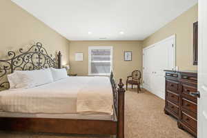 Bedroom featuring light colored carpet and a closet