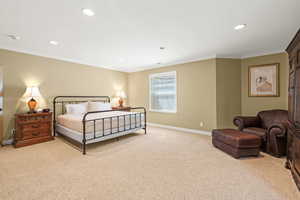 Carpeted bedroom with ornamental molding