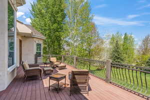 Wooden terrace with an outdoor living space and a lawn