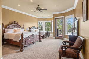 Bedroom featuring ceiling fan, access to exterior, ornamental molding, and carpet floors