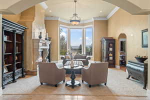 Interior space with a premium fireplace, ornamental molding, and light tile patterned floors