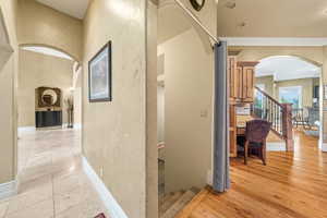 Hallway featuring light wood-type flooring and crown molding