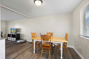 Dining area with dark wood-type flooring