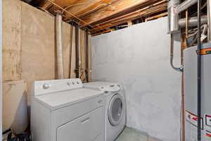 Laundry room featuring gas water heater and washing machine and clothes dryer