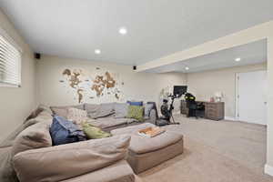 Carpeted living room featuring a textured ceiling