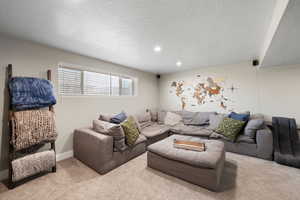 Living room with light colored carpet and a textured ceiling