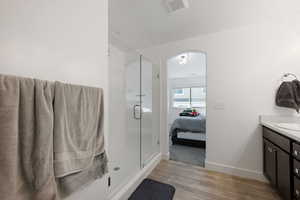 Bathroom featuring hardwood / wood-style floors, an enclosed shower, and vanity