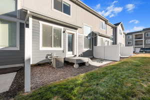 Back of property featuring a lawn and cooling unit