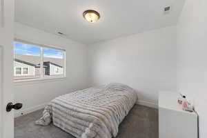 Bedroom featuring dark colored carpet