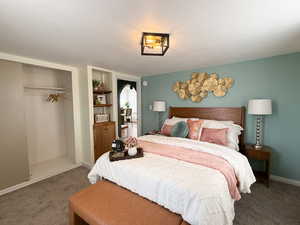 Bedroom featuring a closet, a textured ceiling, and carpet