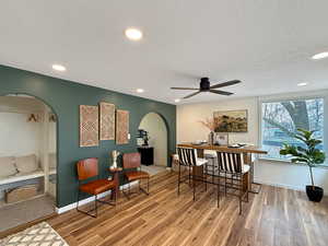 Dining room with ceiling fan, light hardwood / wood-style floors, and a textured ceiling