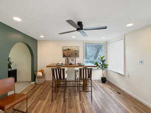 Dining room featuring ceiling fan, a textured ceiling, and light hardwood / wood-style floors