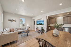 View of Living room, Dinning room, and Kitchen featuring light wood-type flooring and large windows