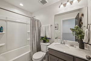 Full bathroom featuring toilet, vanity, and shower / bath combination, gray wood cabinetry and white quarts countertop