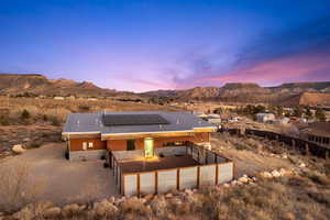 Back house at dusk with a mountain view and solar panels