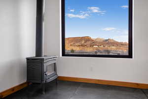 Room details with a mountain view, a wood stove, and concrete flooring