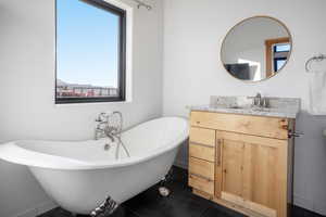 Bathroom with vanity, tile patterned floors, and a bathtub