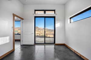 Spare room featuring a high ceiling, a mountain view, and a healthy amount of sunlight