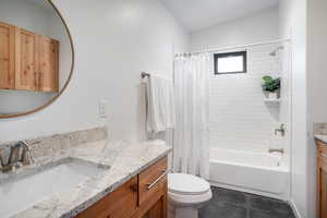 Full bathroom featuring vanity, toilet, shower / tub combo with curtain, and tile patterned flooring