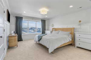 Bedroom with light carpet and ornamental molding