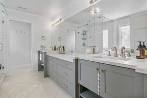 Bathroom featuring vanity, tile patterned floors, and a shower with door