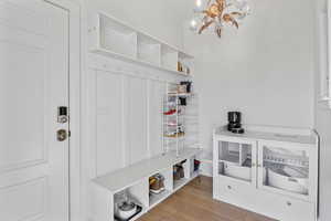 Mudroom featuring a notable chandelier and light wood-type flooring