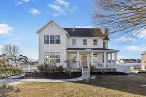 View of front of house with a front yard and a porch