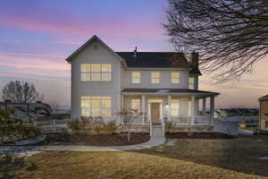 View of front of property featuring a porch and a yard