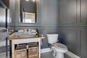 Bathroom featuring sink, toilet, and tile patterned flooring