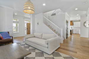 Living room with crown molding and light hardwood / wood-style floors