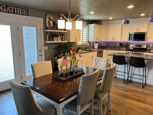 Dining space featuring sink, hardwood / wood-style flooring, a chandelier, and a textured ceiling