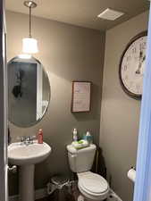 Bathroom featuring sink, a textured ceiling, and toilet