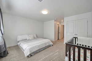 Carpeted bedroom featuring a closet